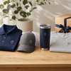 FirstMark Direct custom branded merch — navy embroidered polo, gray logo cap, navy tumbler, and gray tee with a gift box