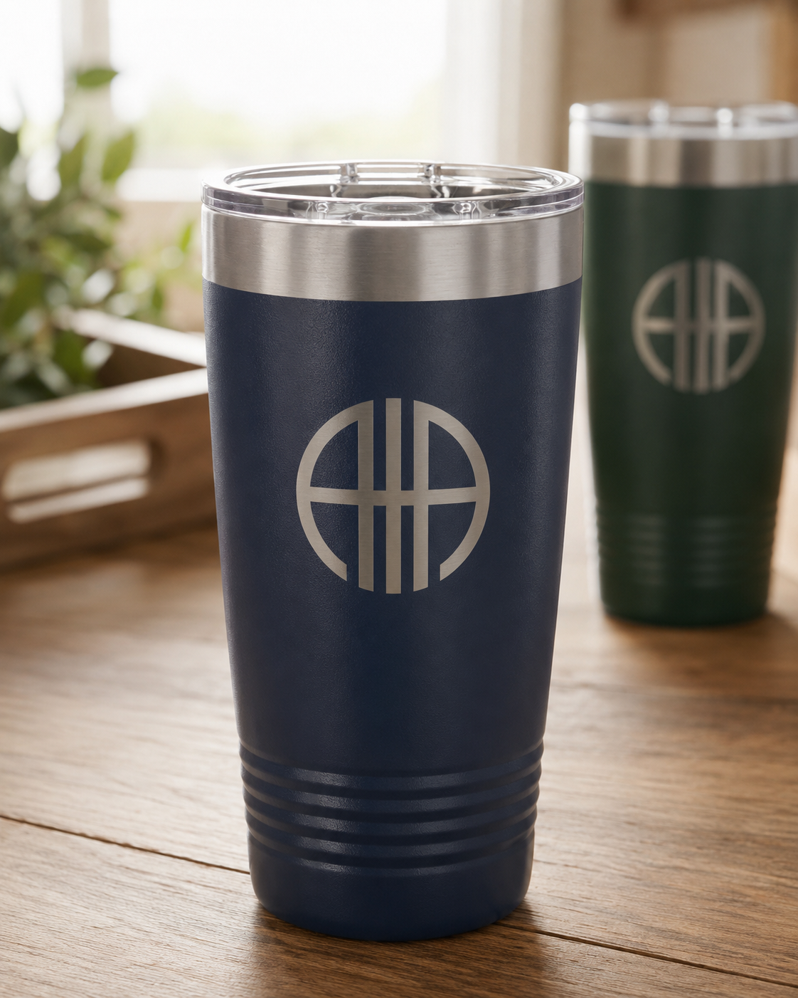 Custom engraved tumbler with a business logo — navy Polar Camel tumbler laser engraved, on an oak counter